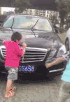 两个小孩子 汽车 淘气 掰车标